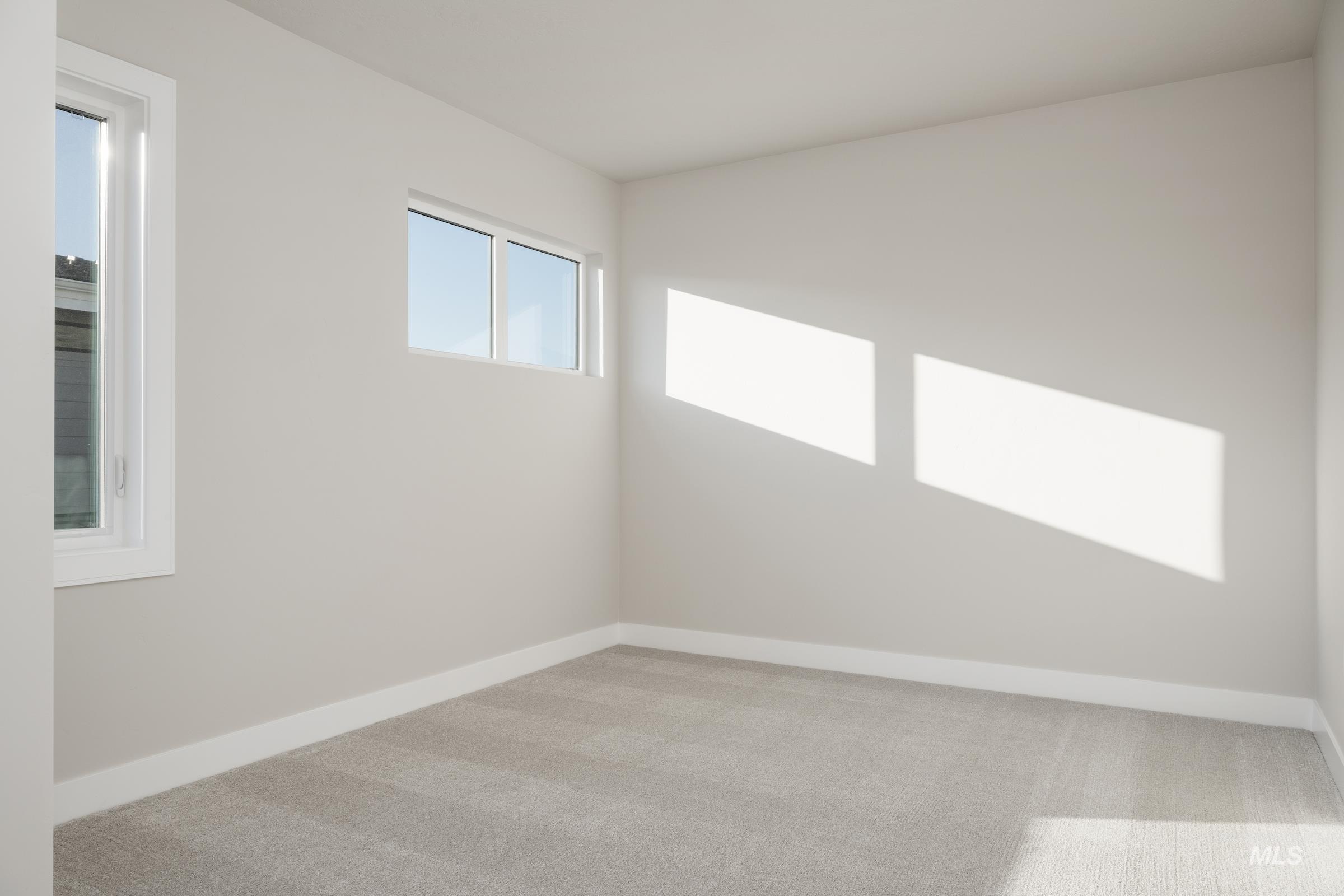 Unfurnished room with light colored carpet and baseboards