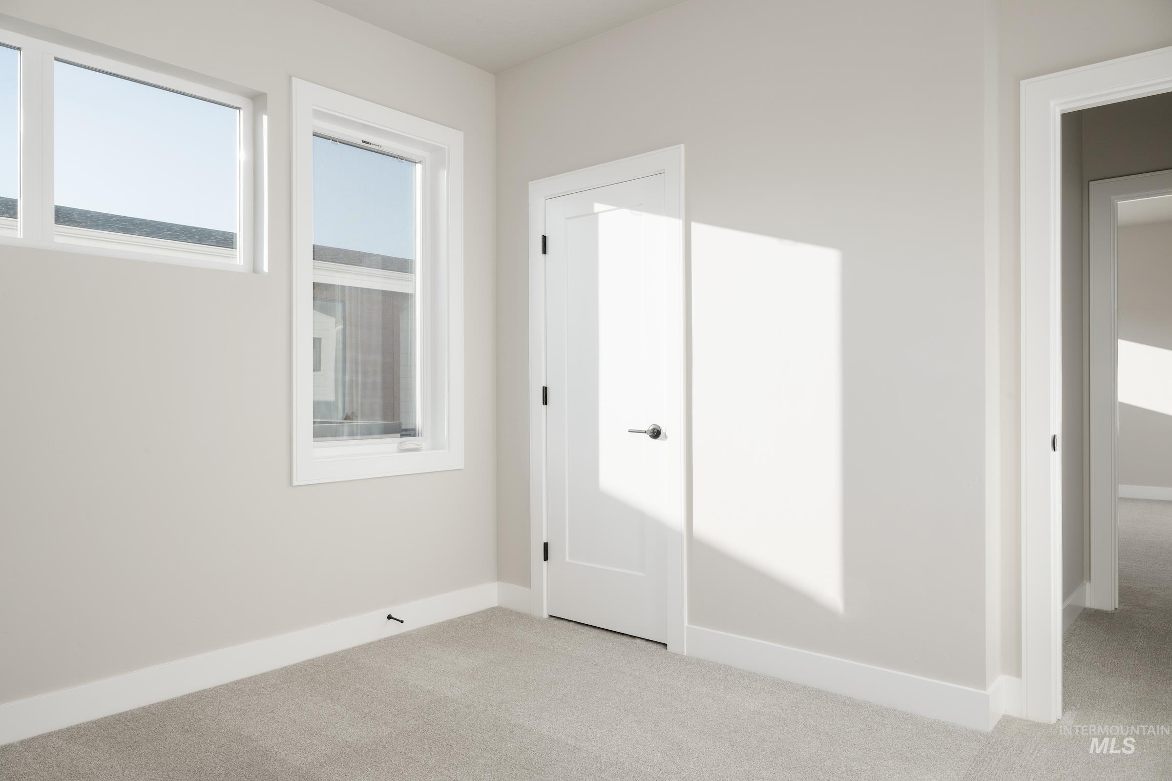 Unfurnished bedroom featuring baseboards and light carpet