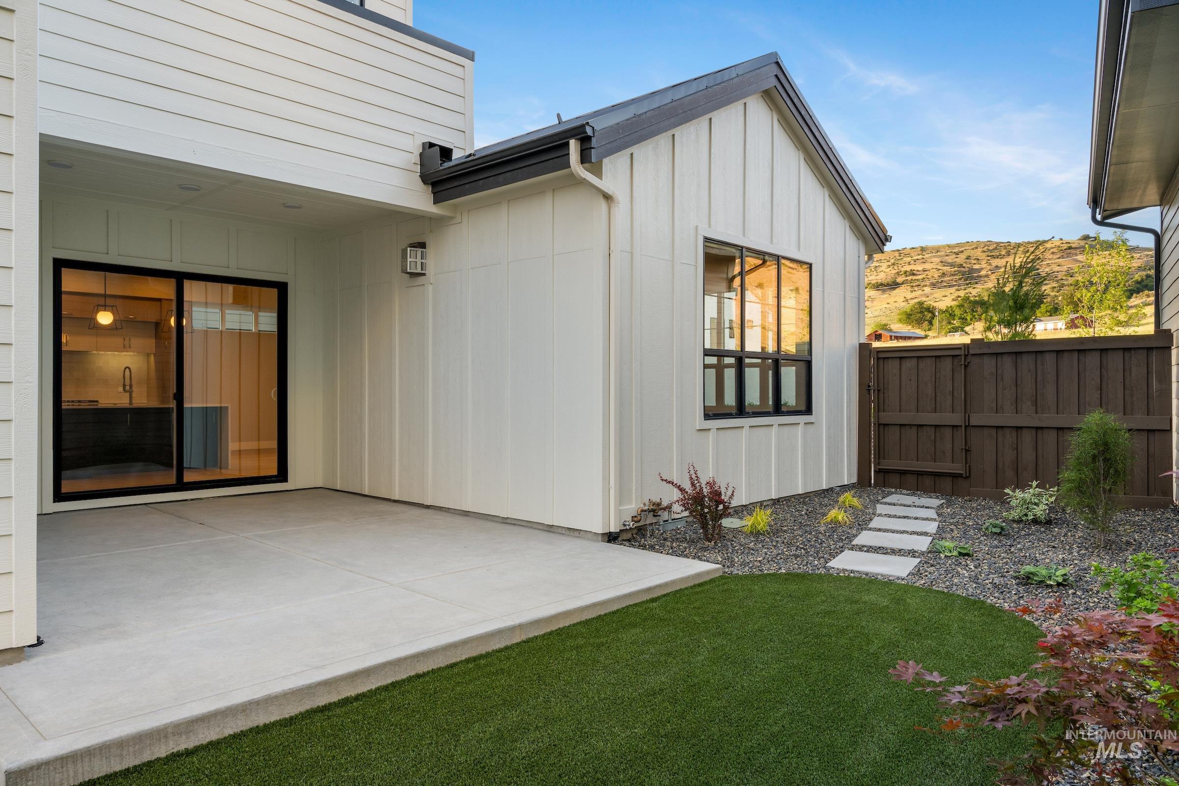 Back of house with board and batten siding and a patio area