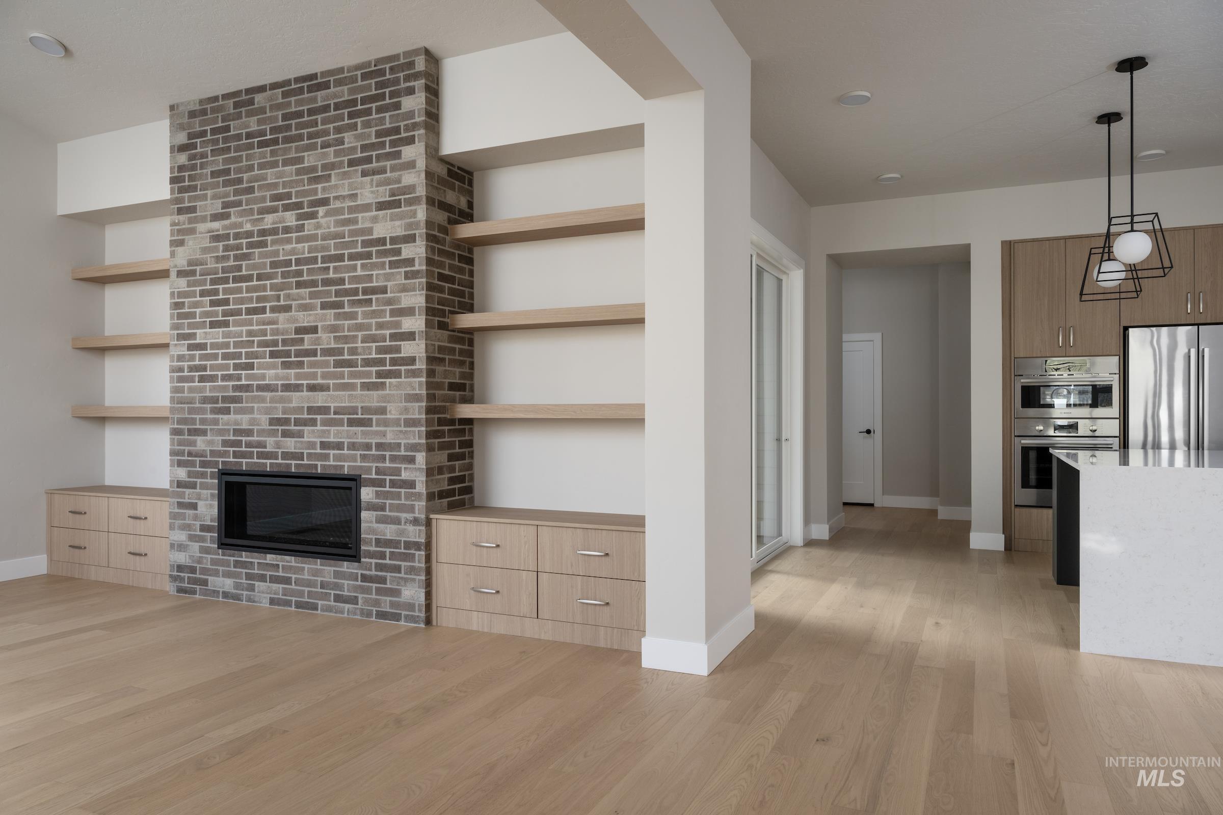 Unfurnished living room with light wood-type flooring, a fireplace, and recessed lighting