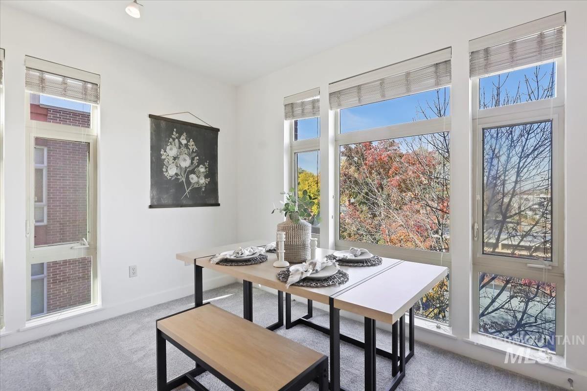 Dining room with light colored carpet and baseboards