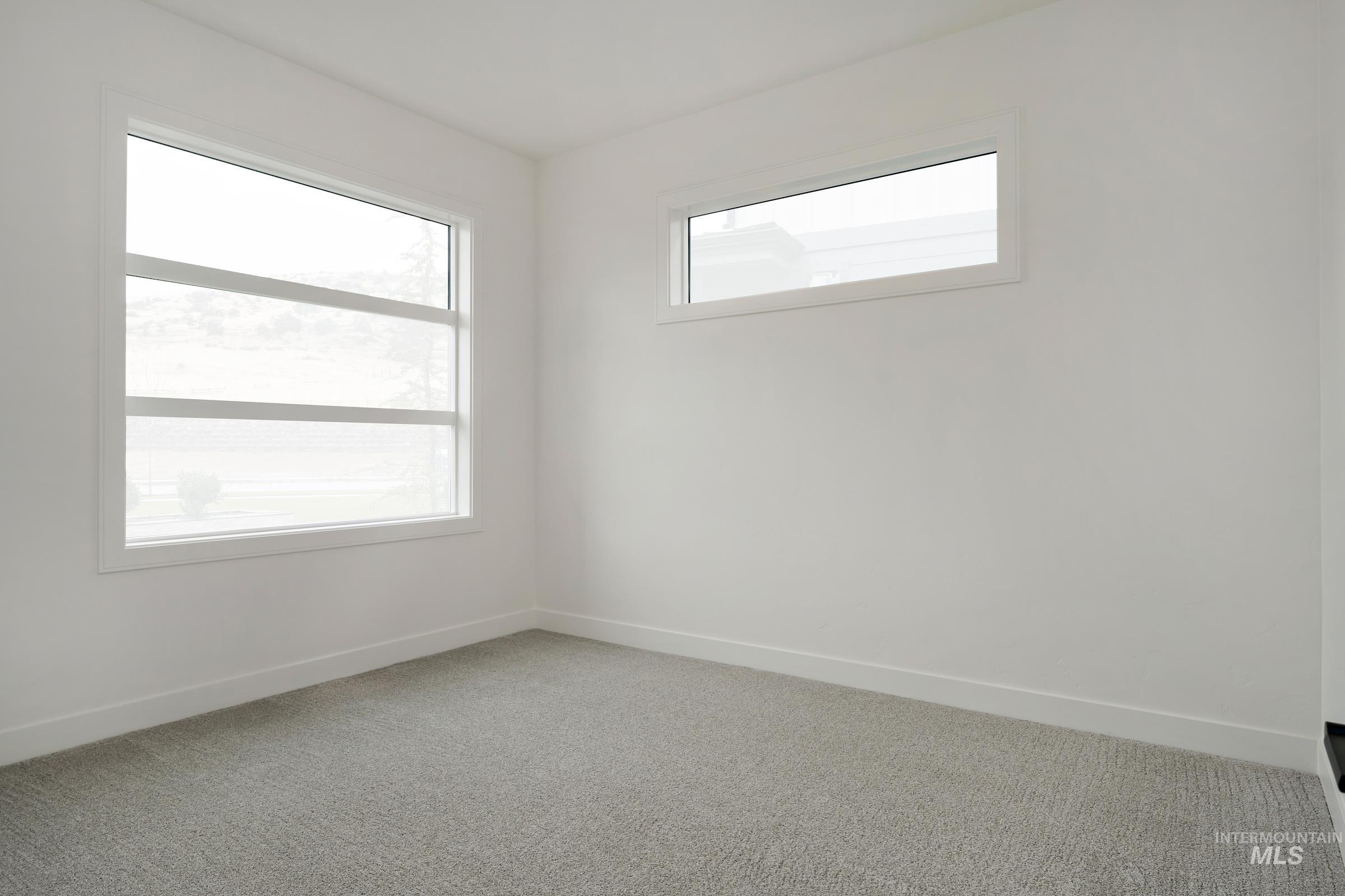 Carpeted empty room featuring baseboards