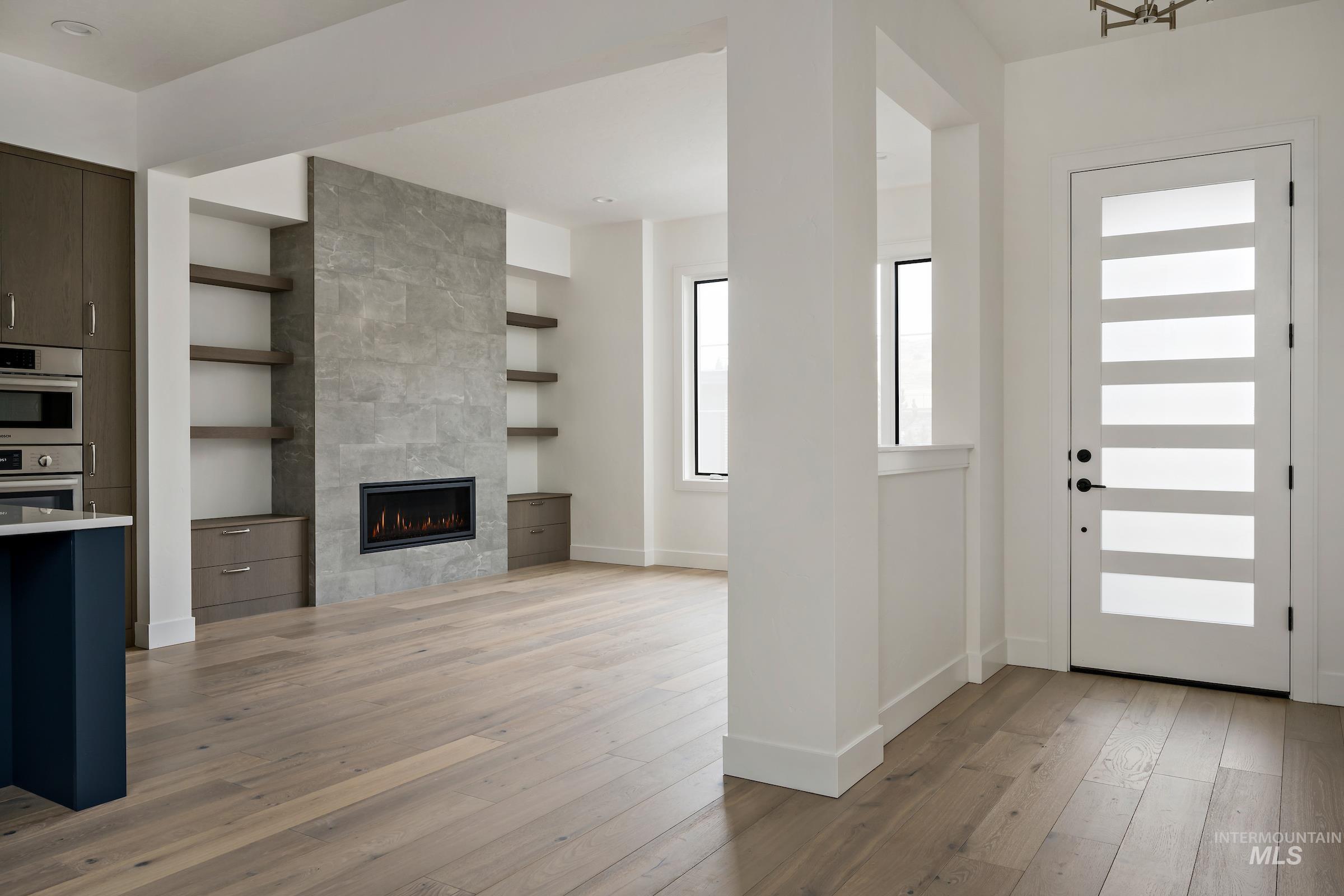 Foyer entrance featuring light wood-style flooring and a tiled fireplace