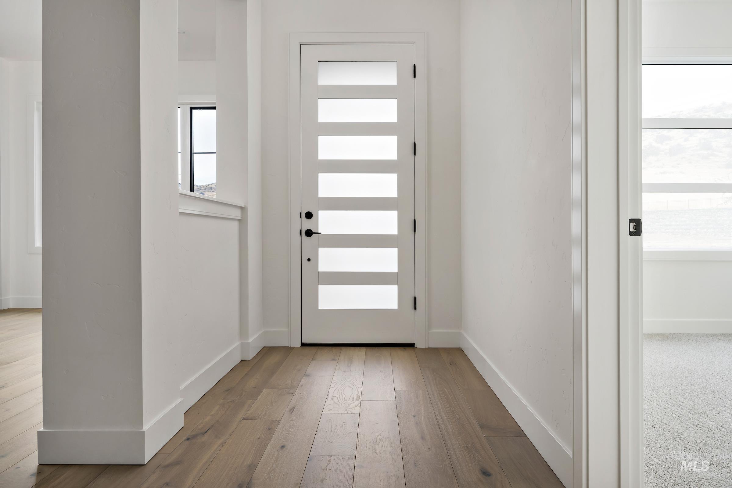 Entrance foyer with baseboards and light wood-style floors