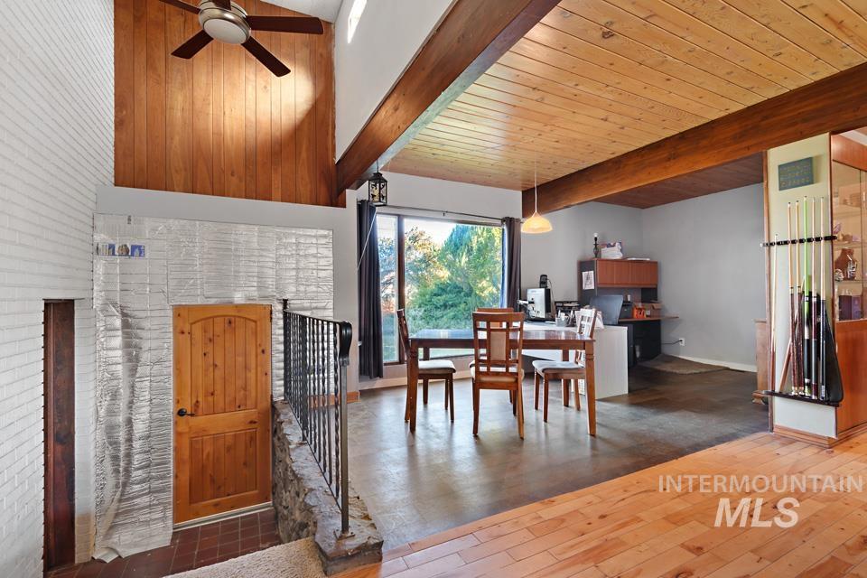 Dining space featuring wood-type flooring, a wooden ceiling with exposed beams, and ceiling fan