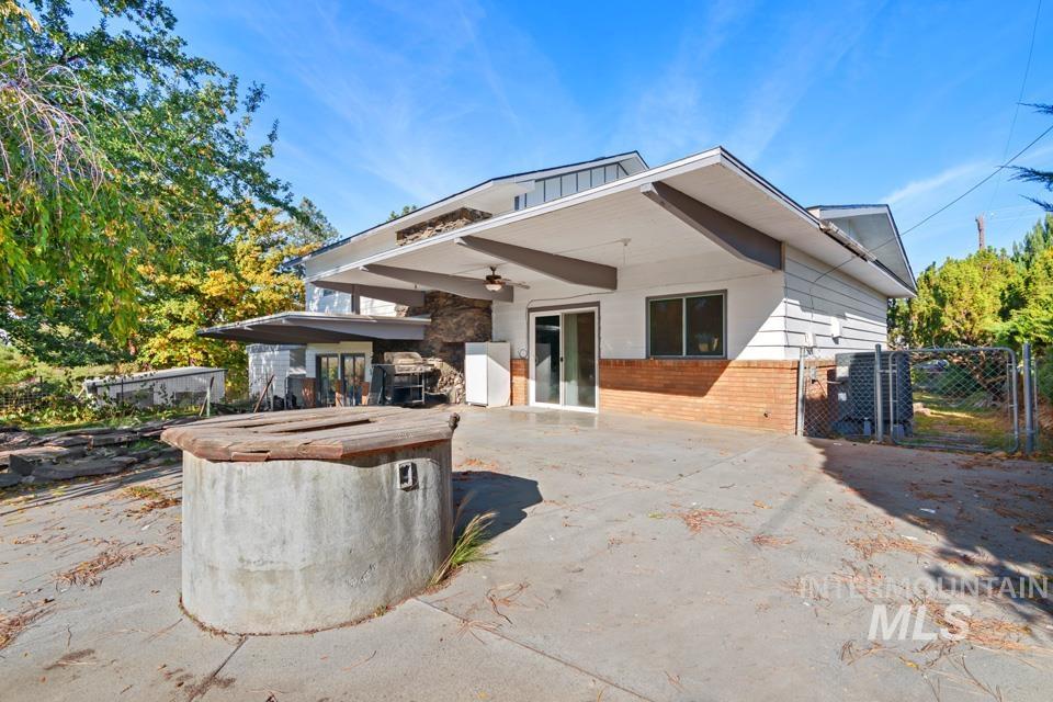 Rear view of property featuring a ceiling fan, a patio, a gate, and brick siding