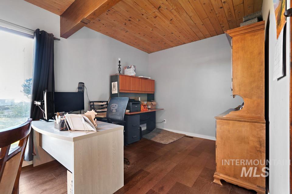 Office space with dark wood-type flooring and wood ceiling