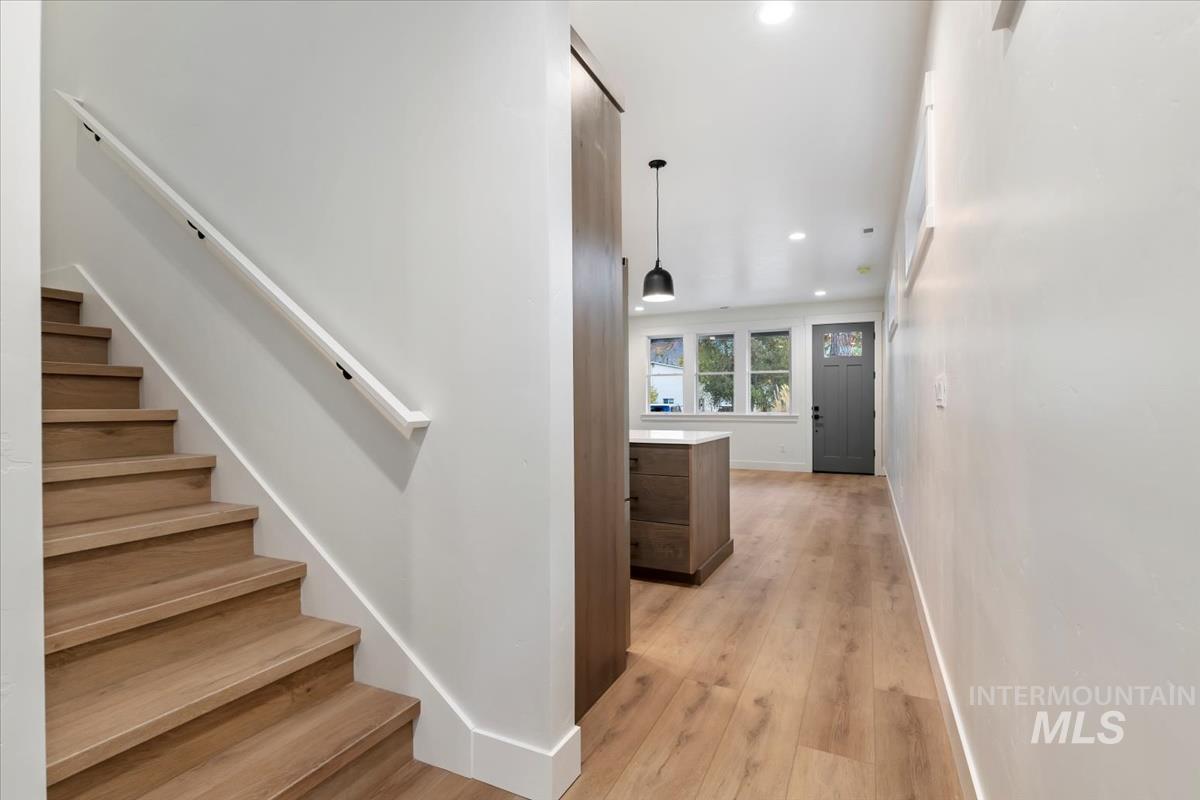 Stairway with recessed lighting and hardwood / wood-style floors