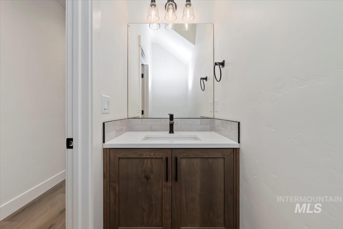 Half bathroom featuring vanity and wood finished floors