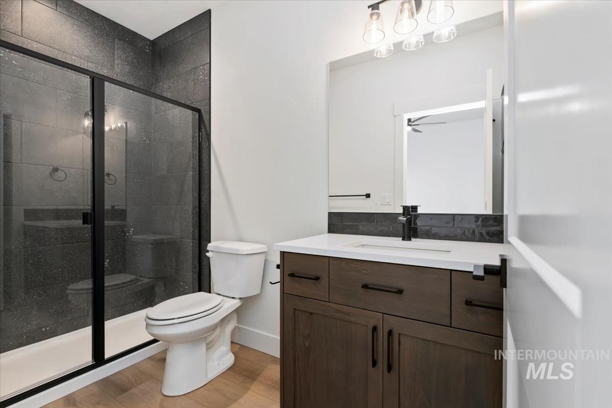 Bathroom featuring vanity, a shower stall, and light wood-style floors