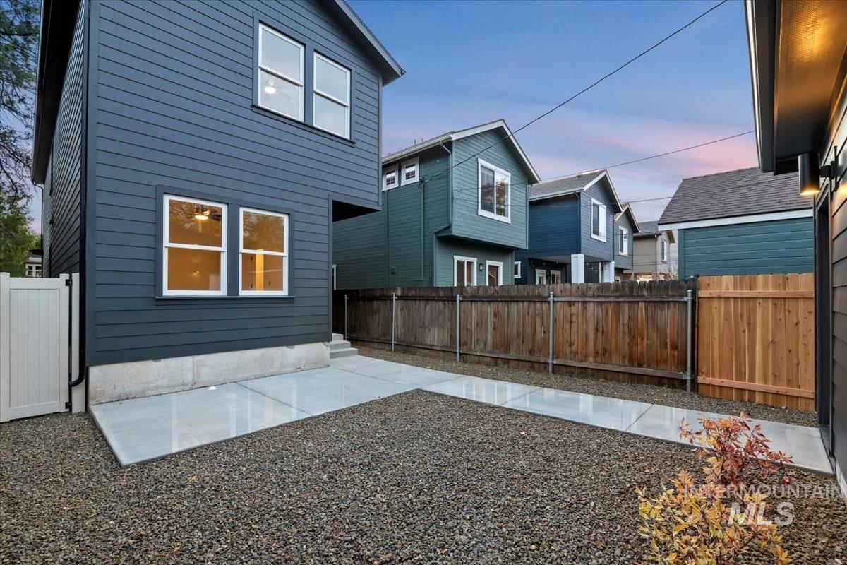 Back of property with a fenced backyard, a residential view, and a patio area