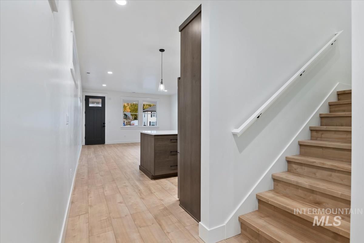 Staircase featuring wood-type flooring and recessed lighting