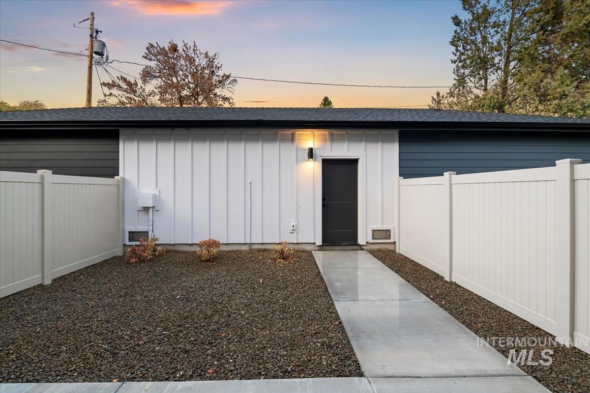 View of front of home with board and batten siding and roof with shingles