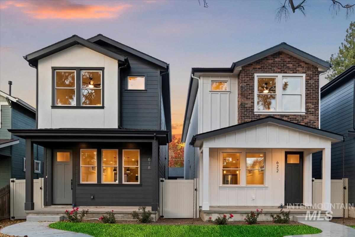 Contemporary house with a gate, a porch, board and batten siding, and brick siding