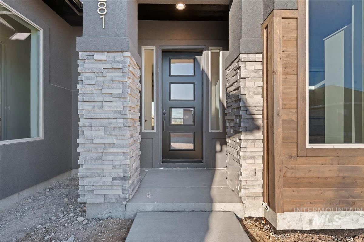 Entrance to property with stone siding and stucco siding