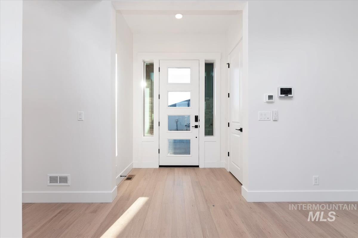 Entrance foyer featuring baseboards and light wood-style flooring