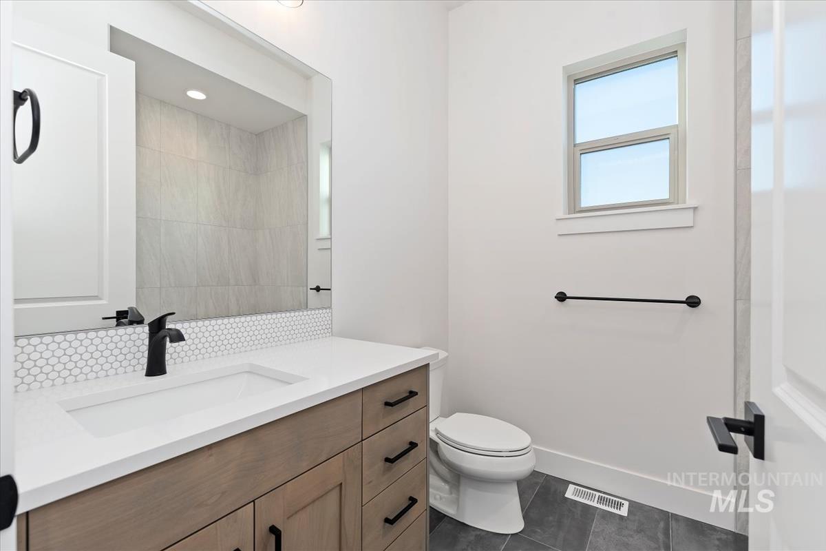 Bathroom with vanity and dark tile patterned floors