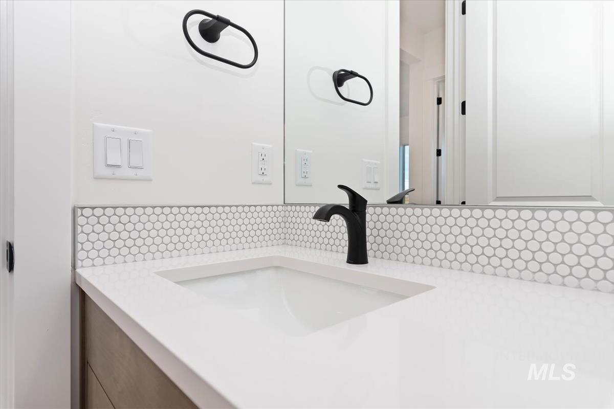 Bathroom with vanity and tasteful backsplash