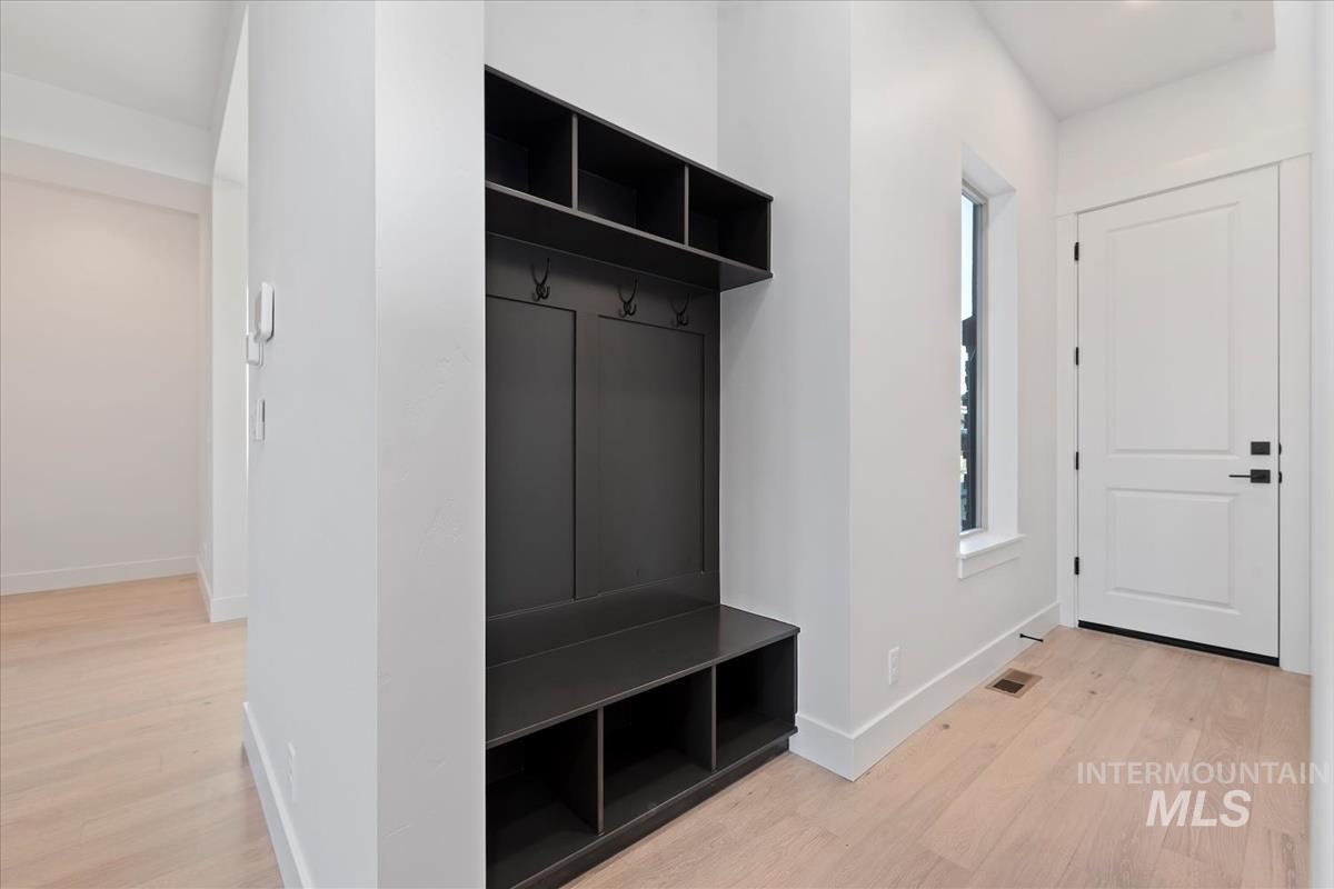 Mudroom with light wood-style floors and baseboards