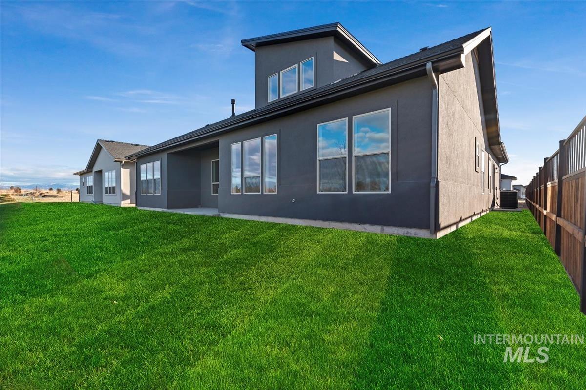Rear view of property featuring a patio, stucco siding, and a lawn