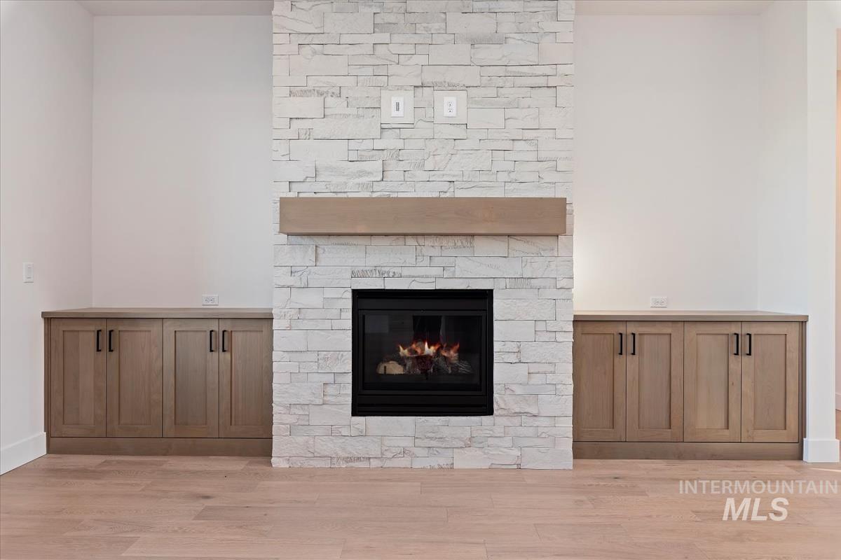 Detailed view of wood finished floors and a stone fireplace