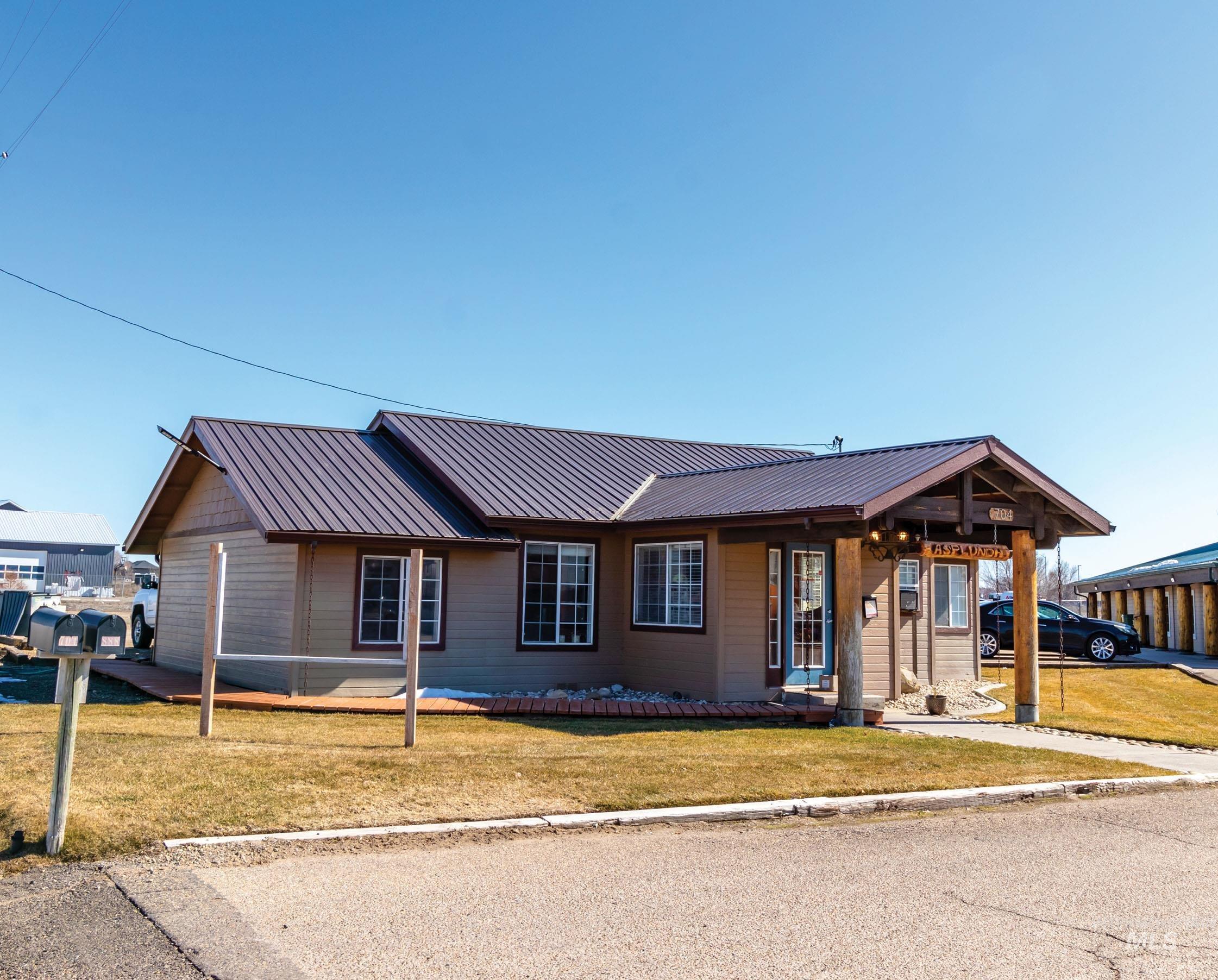 Ranch-style house with a front yard, a metal roof, and covered porch