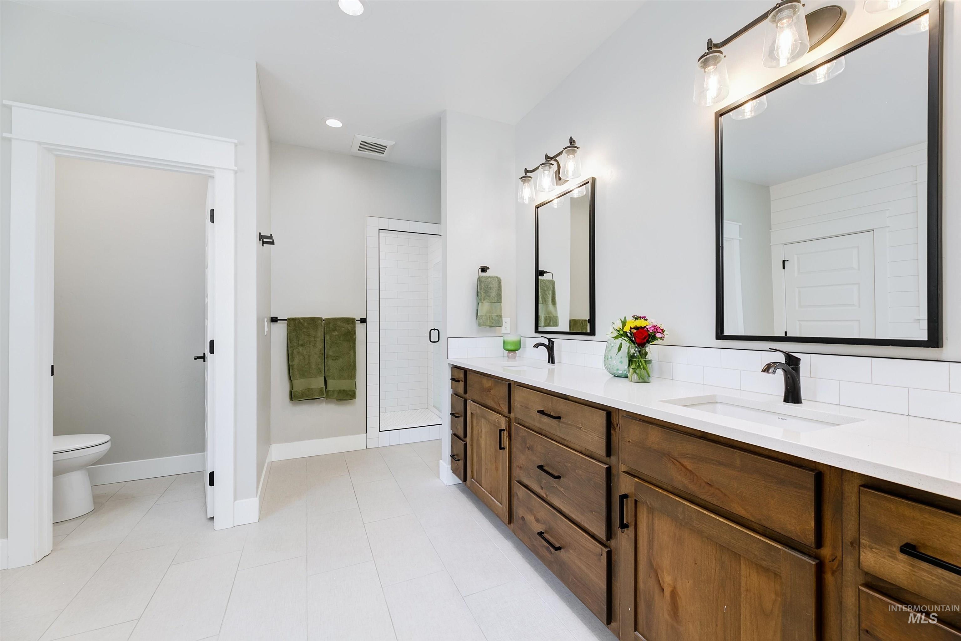 Spa like primary bathroom with double vanity, quartz counter tops, free stand bathtub and fully tiled walk-in shower