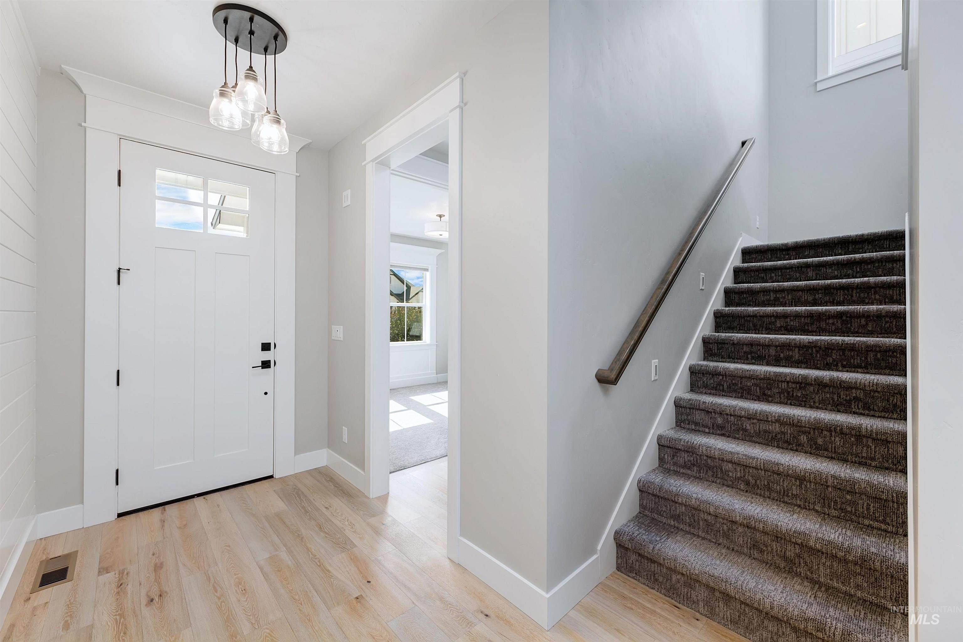 Entrance foyer featuring stairway and light wood finished floors