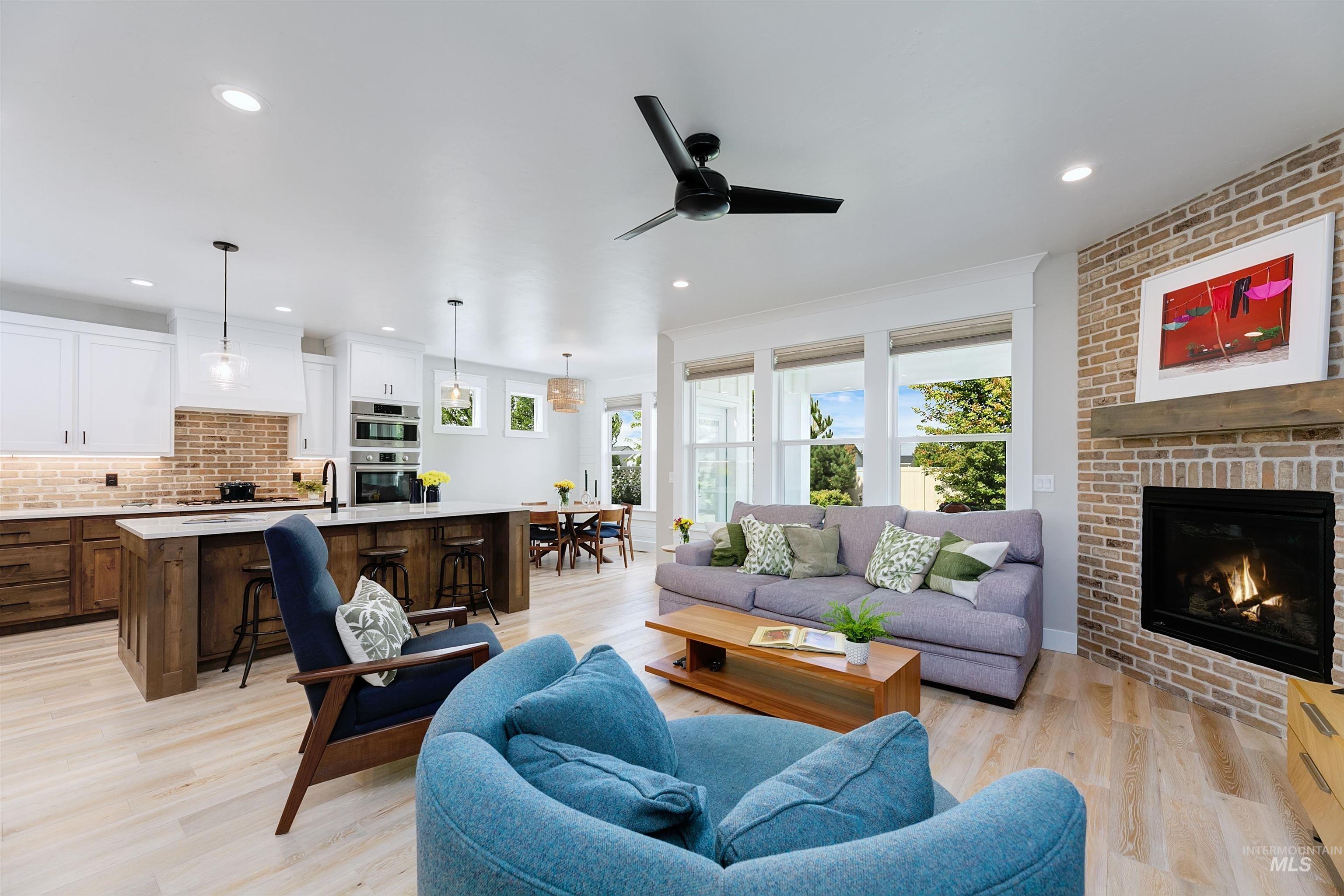 Featuring luxury vinyl plank flooring, contemporary floor to ceiling brick fireplace, and recessed lighting.