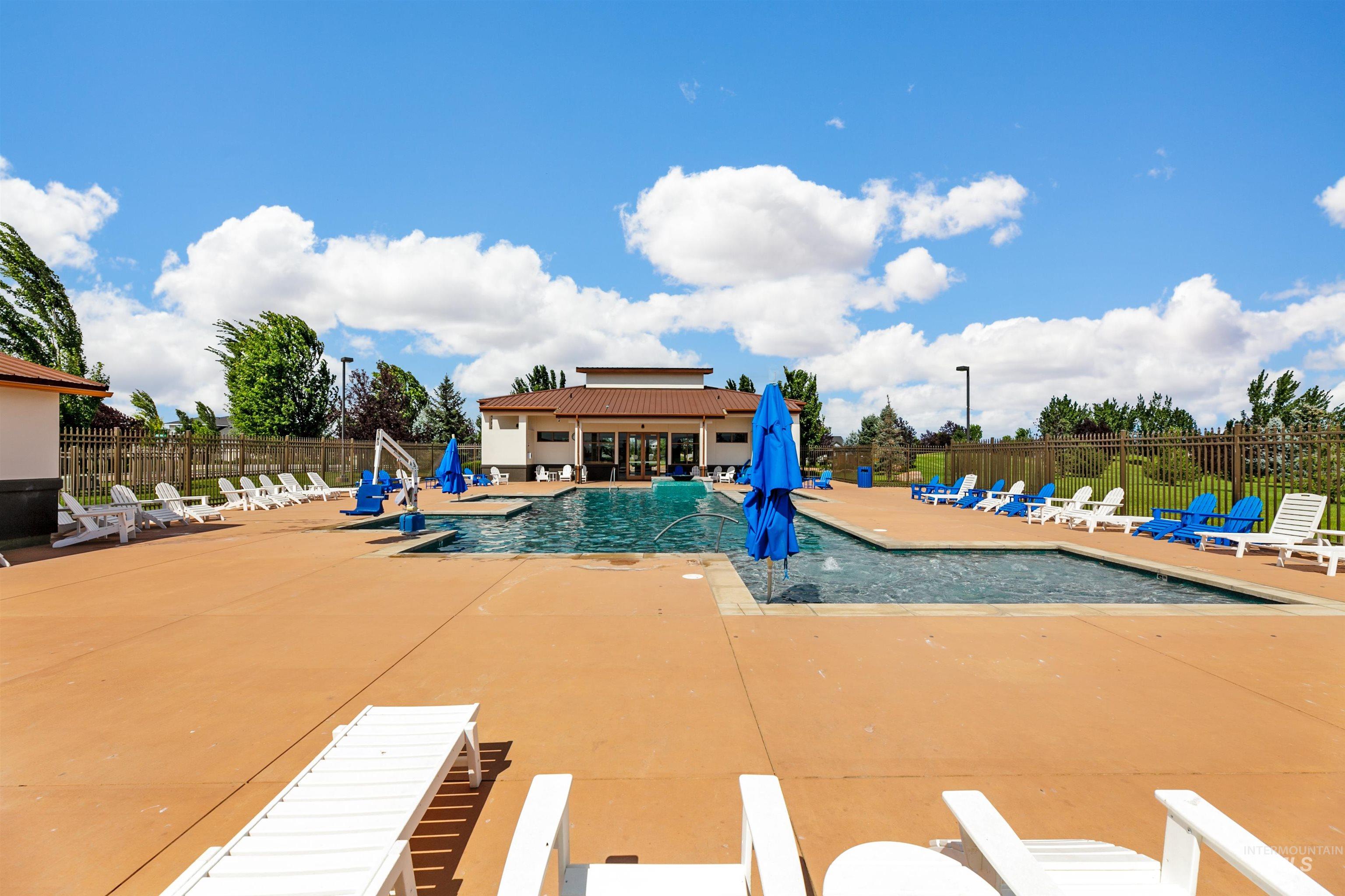 Community pool featuring a spacious and lovely patio area.