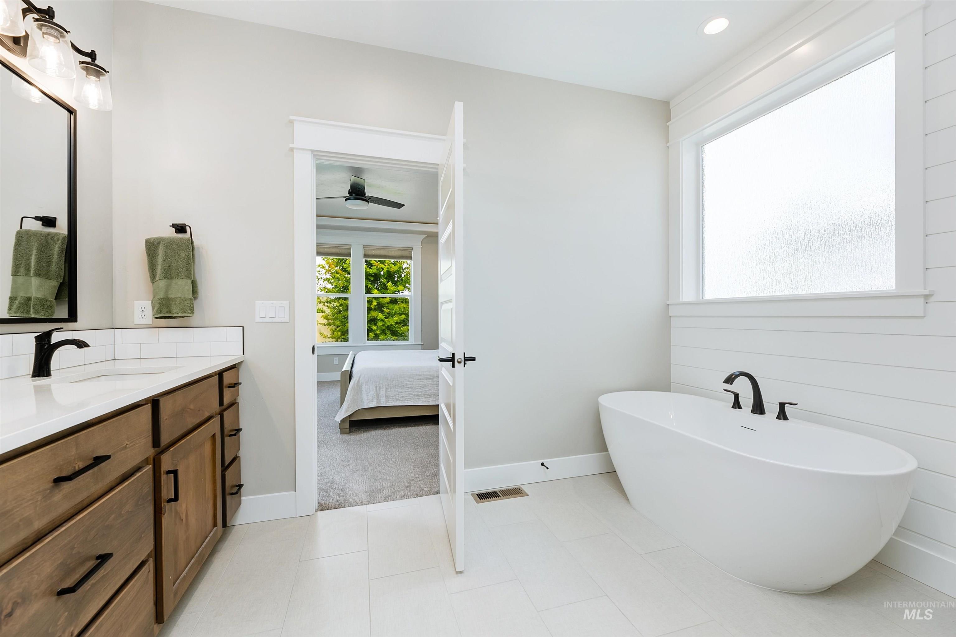 Relax in the spa-like ensuite bathroom featuring a sleek freestanding soaking bathtub, walk in shower and beautiful slab quartz counter tops.