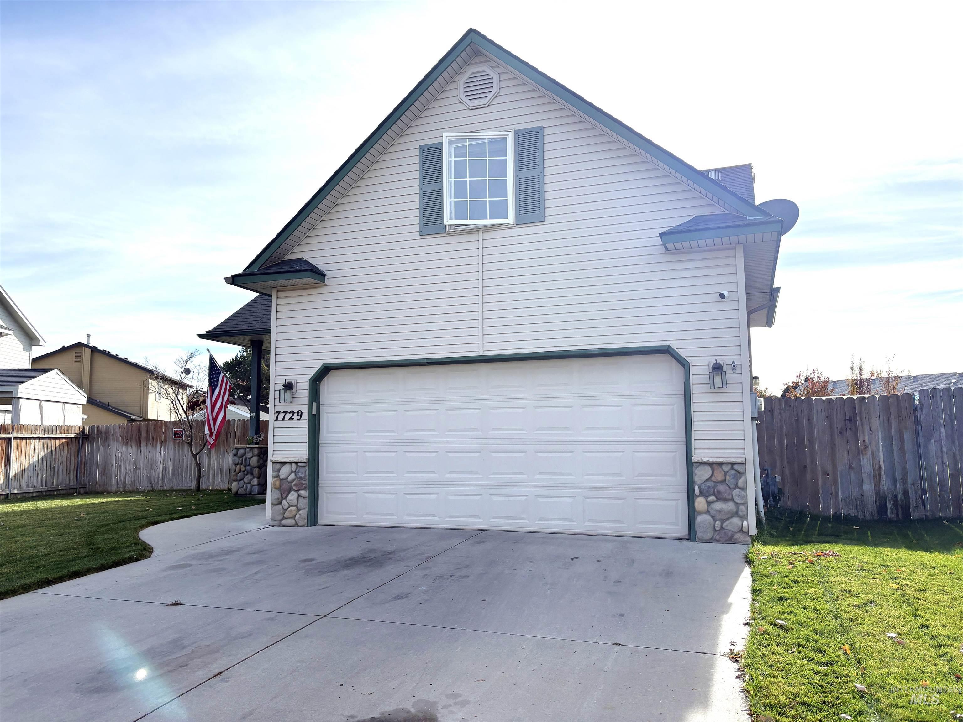 View of front facade featuring stone siding, concrete driveway, and a garage