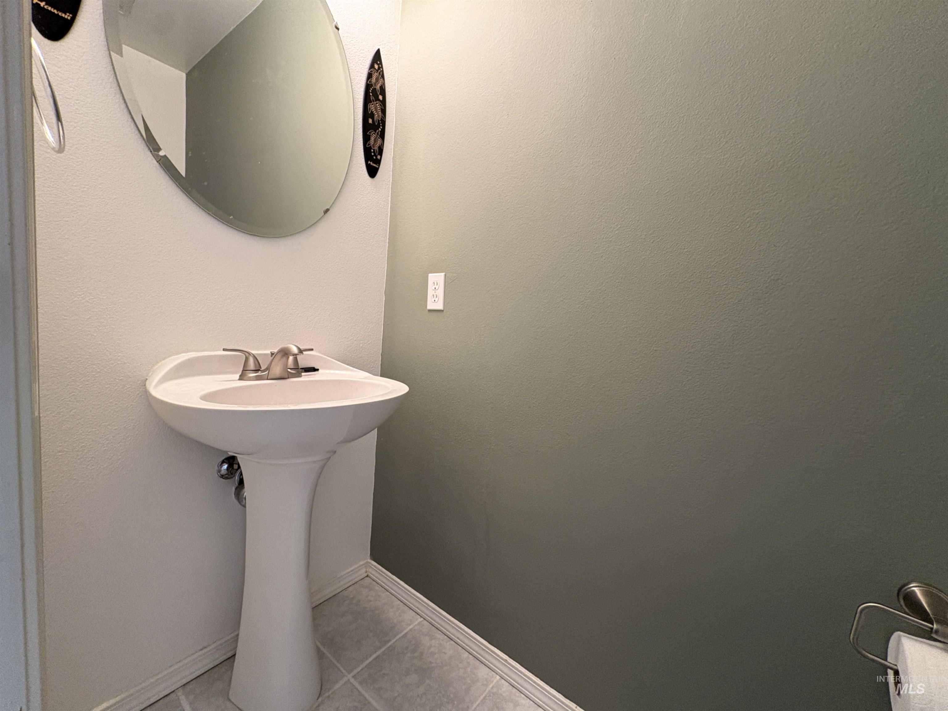 Bathroom with light tile patterned flooring and baseboards