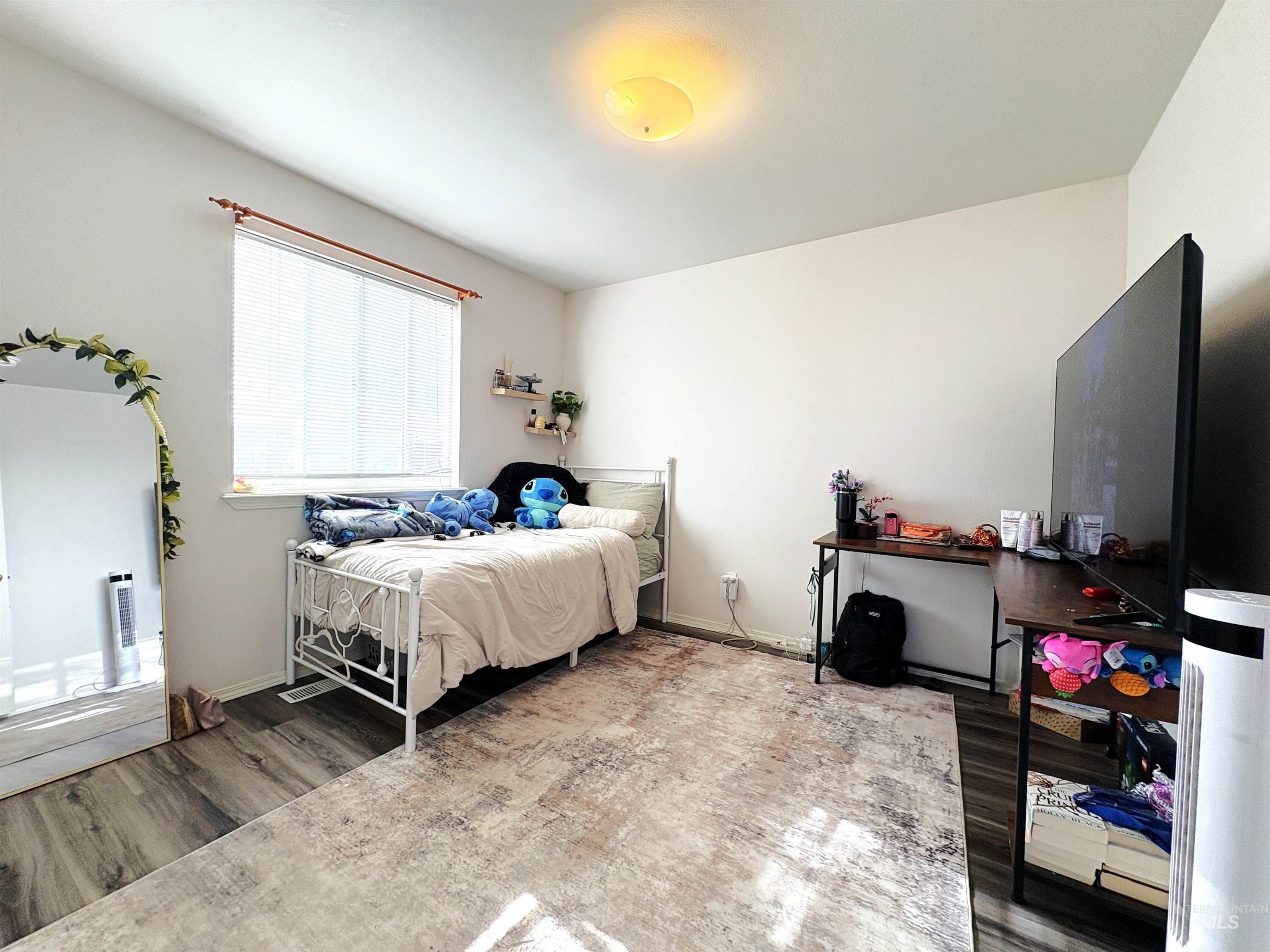 Bedroom with wood finished floors and baseboards