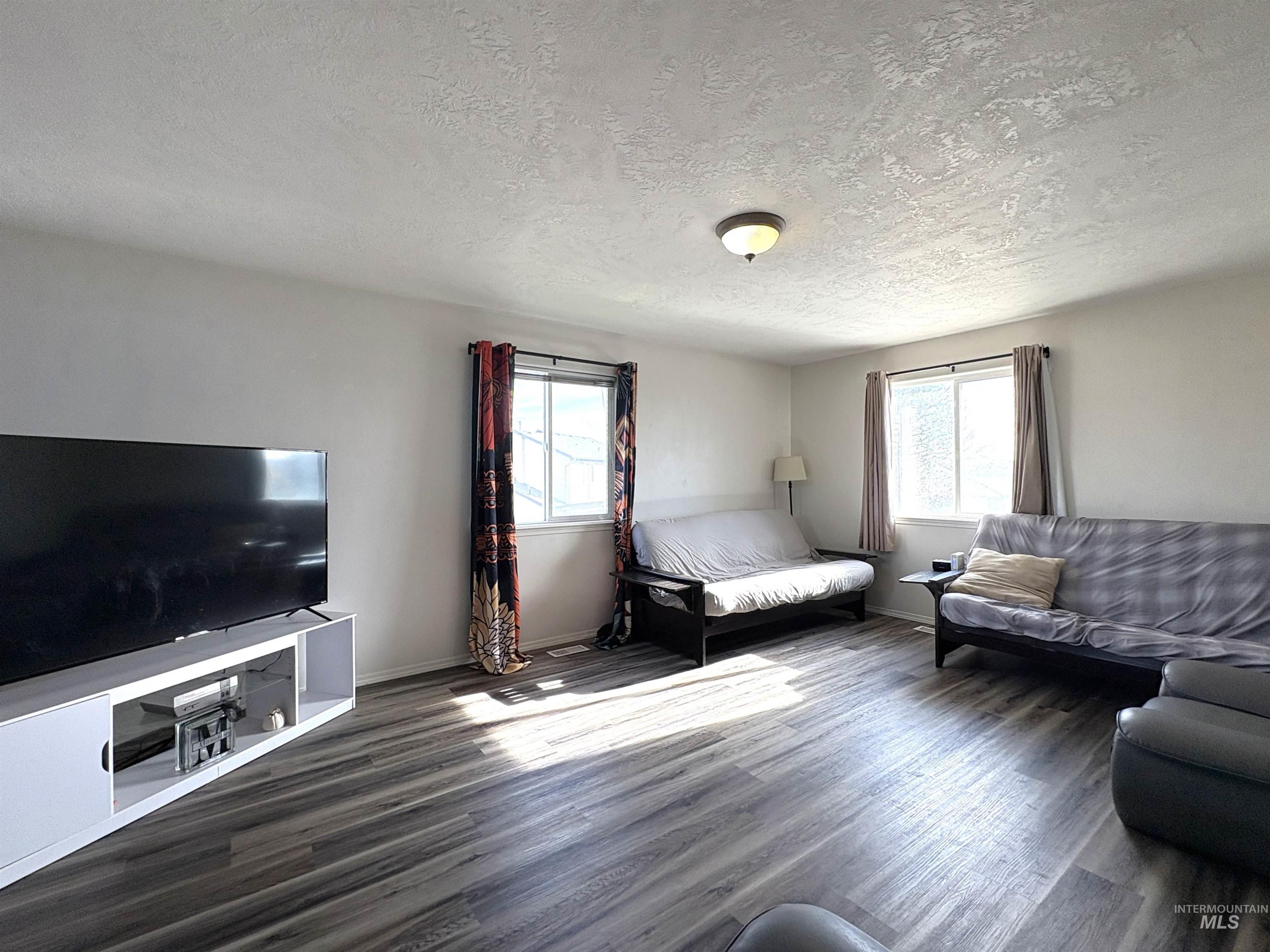 Bonus Room with dark wood-style floors and a textured ceiling