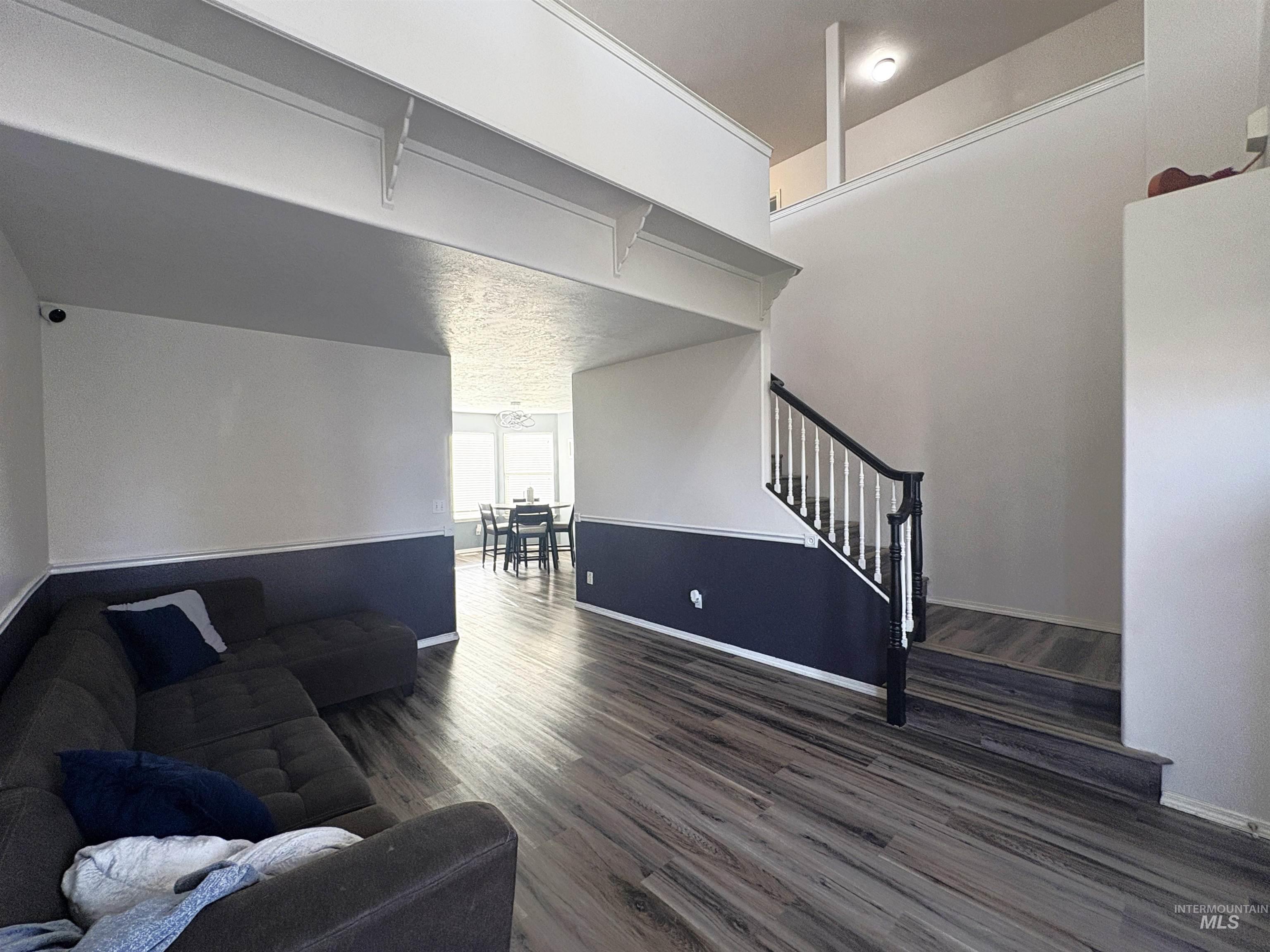 Living area featuring dark wood-type flooring and stairs