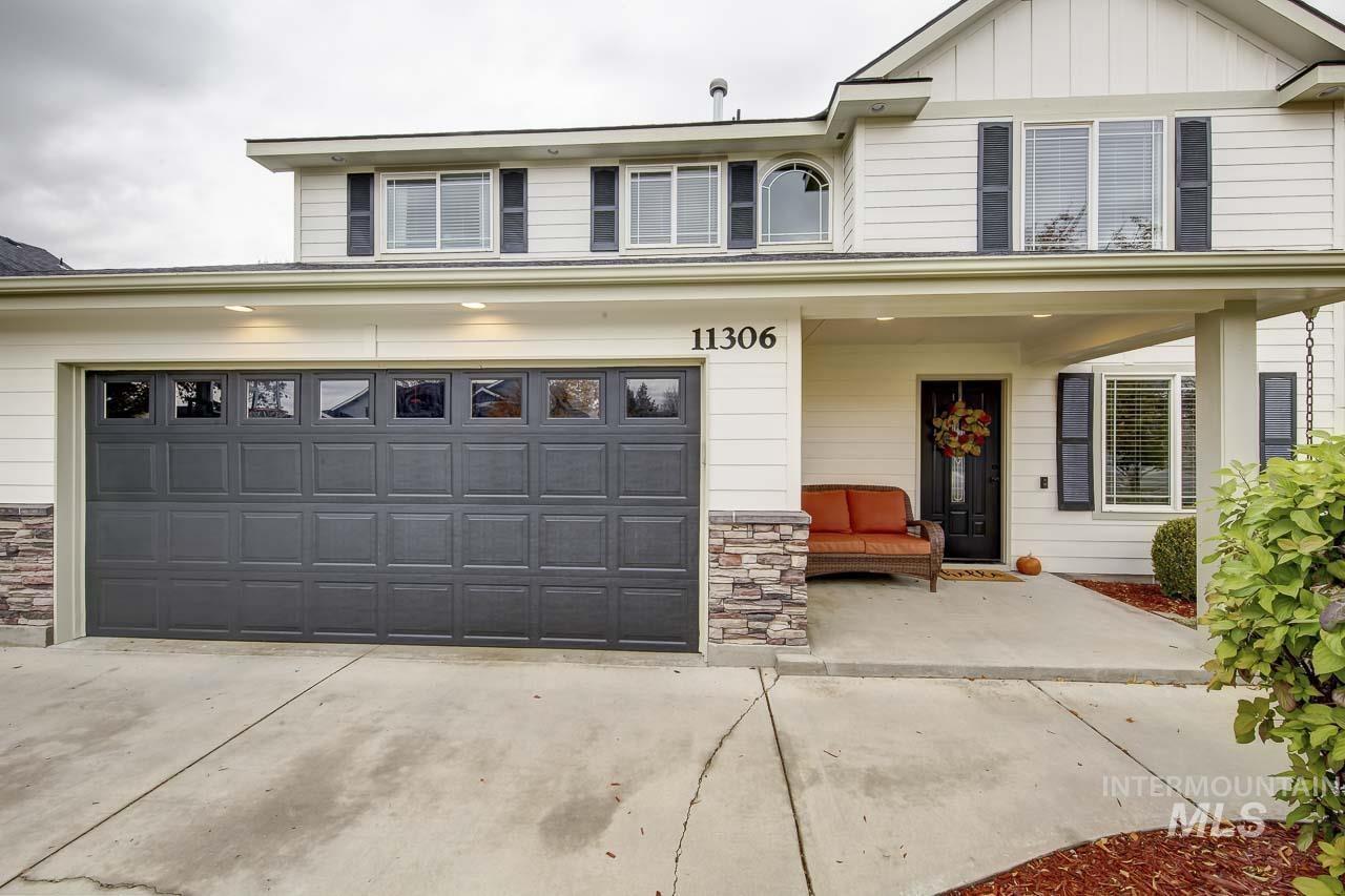 Traditional-style home with a porch, board and batten siding, stone siding, concrete driveway, and a garage