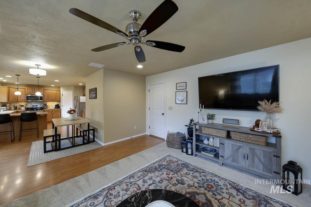 Living room featuring light wood-type flooring, recessed lighting, and ceiling fan