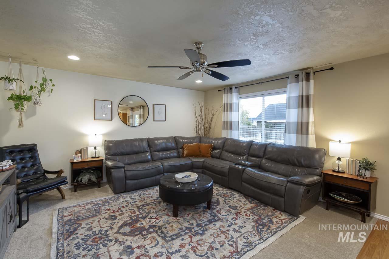 Living area with ceiling fan and a textured ceiling