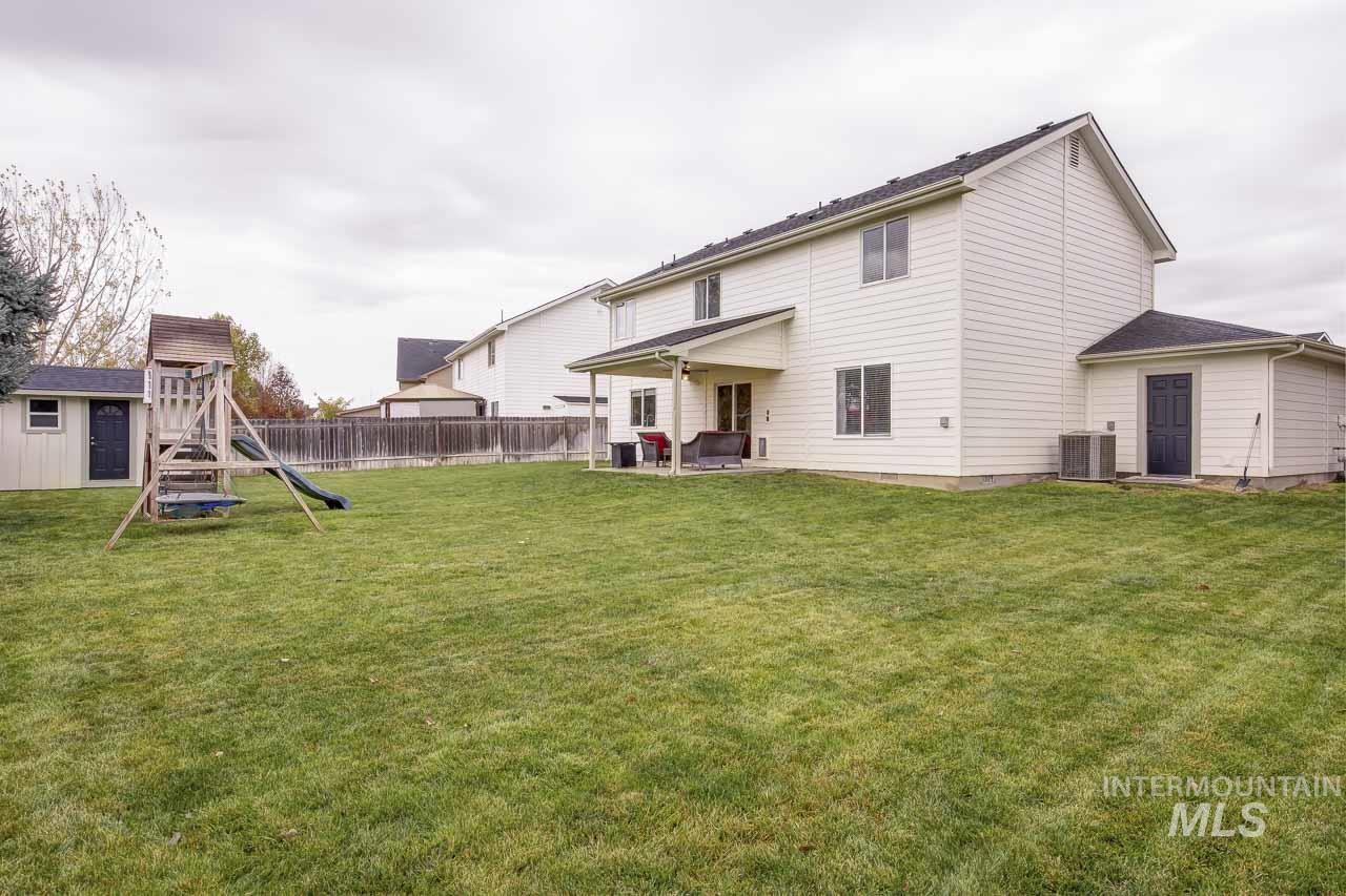 Back of property featuring a patio, a playground, a fenced backyard, and an outdoor structure