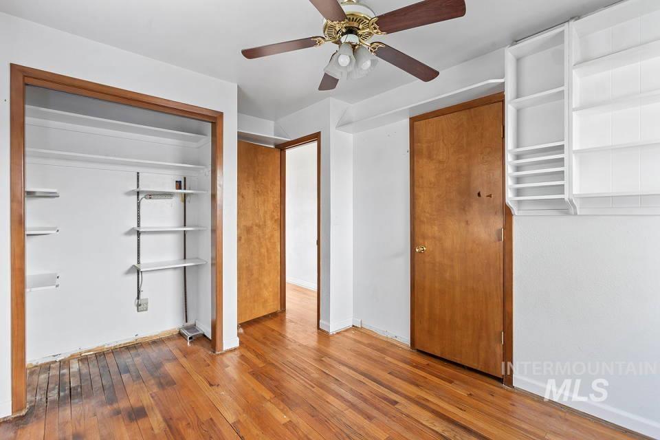 Unfurnished bedroom featuring wood-type flooring, ceiling fan, and a closet
