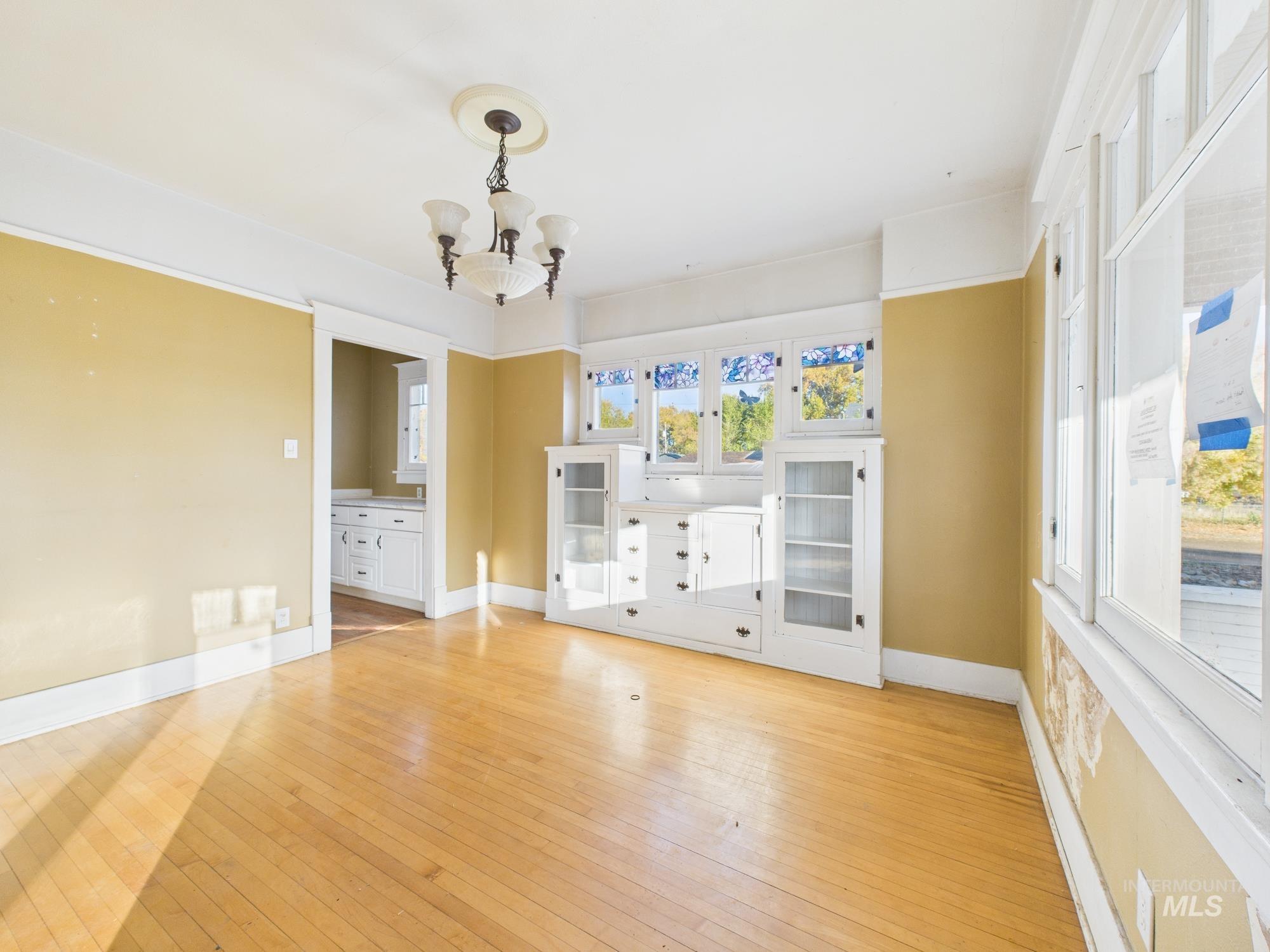 Unfurnished living room featuring light wood-style floors and a chandelier