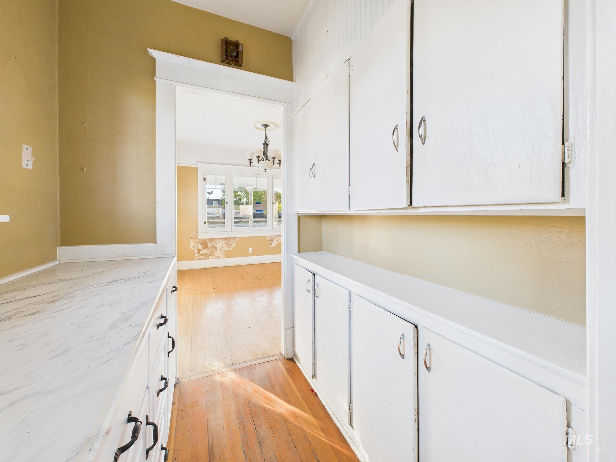 Corridor with light wood-style floors and a chandelier