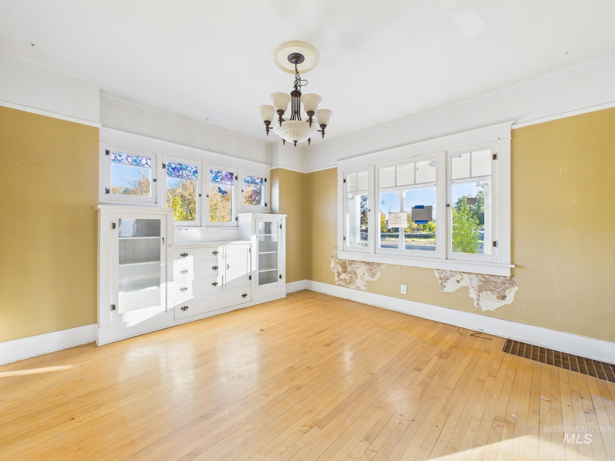 Unfurnished room with light wood-style flooring and a chandelier