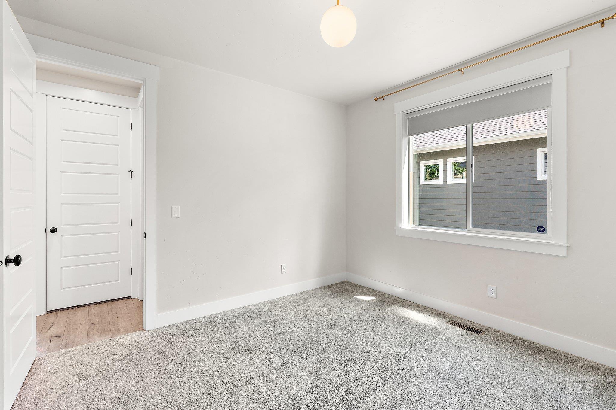 Carpeted spare room with baseboards