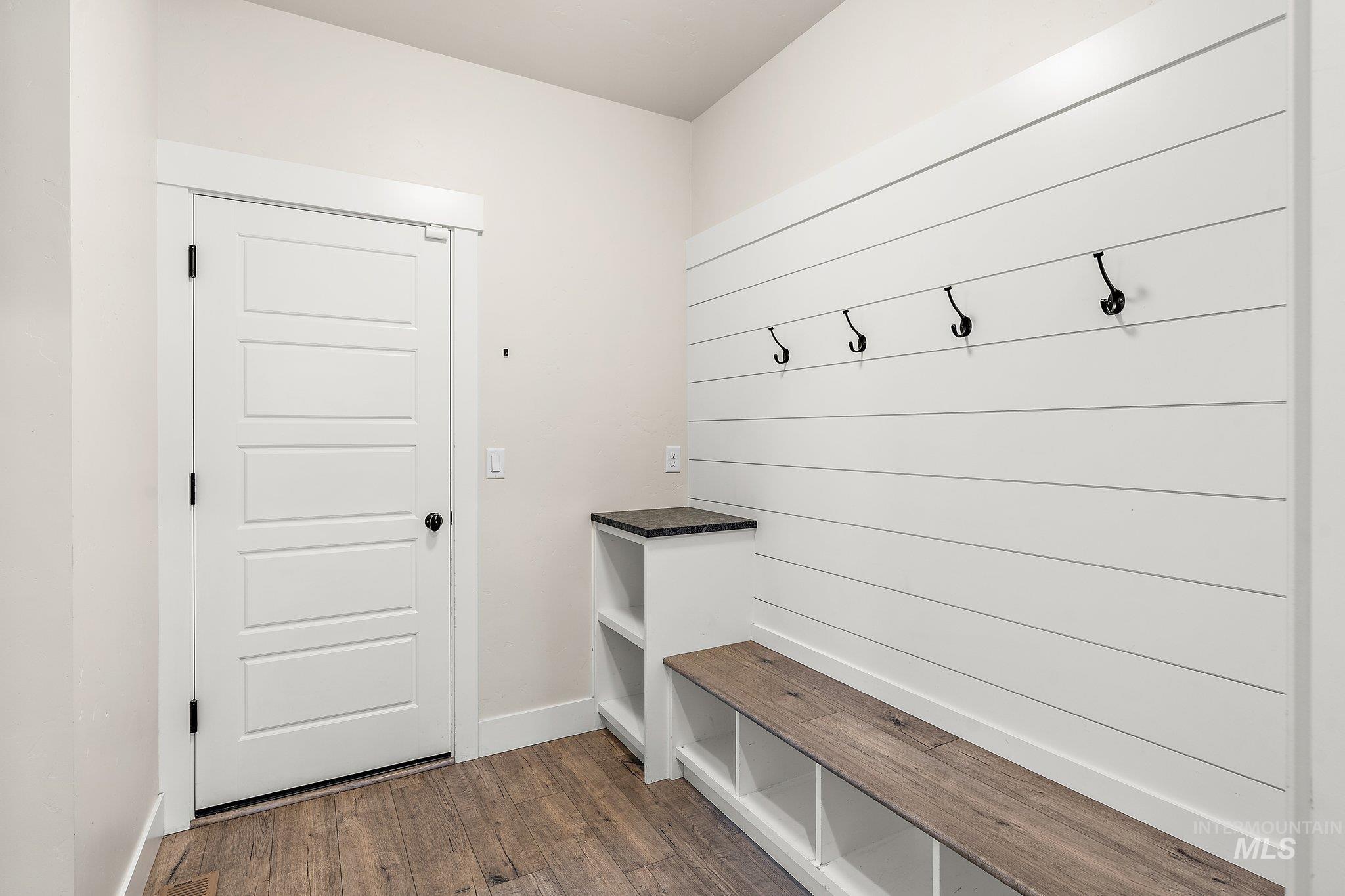 Mudroom featuring dark wood-style floors and baseboards