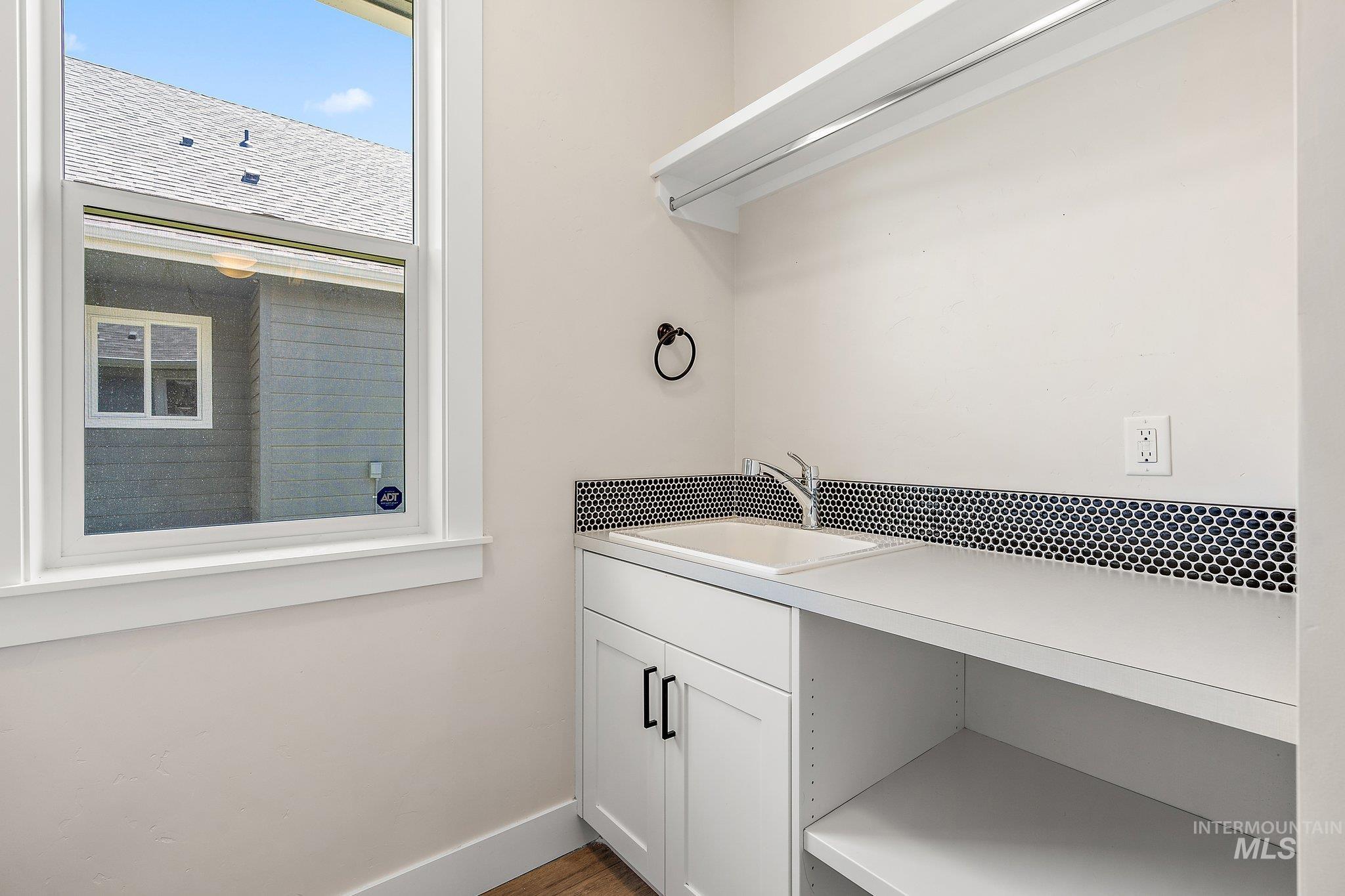 Laundry area with a sink and baseboards
