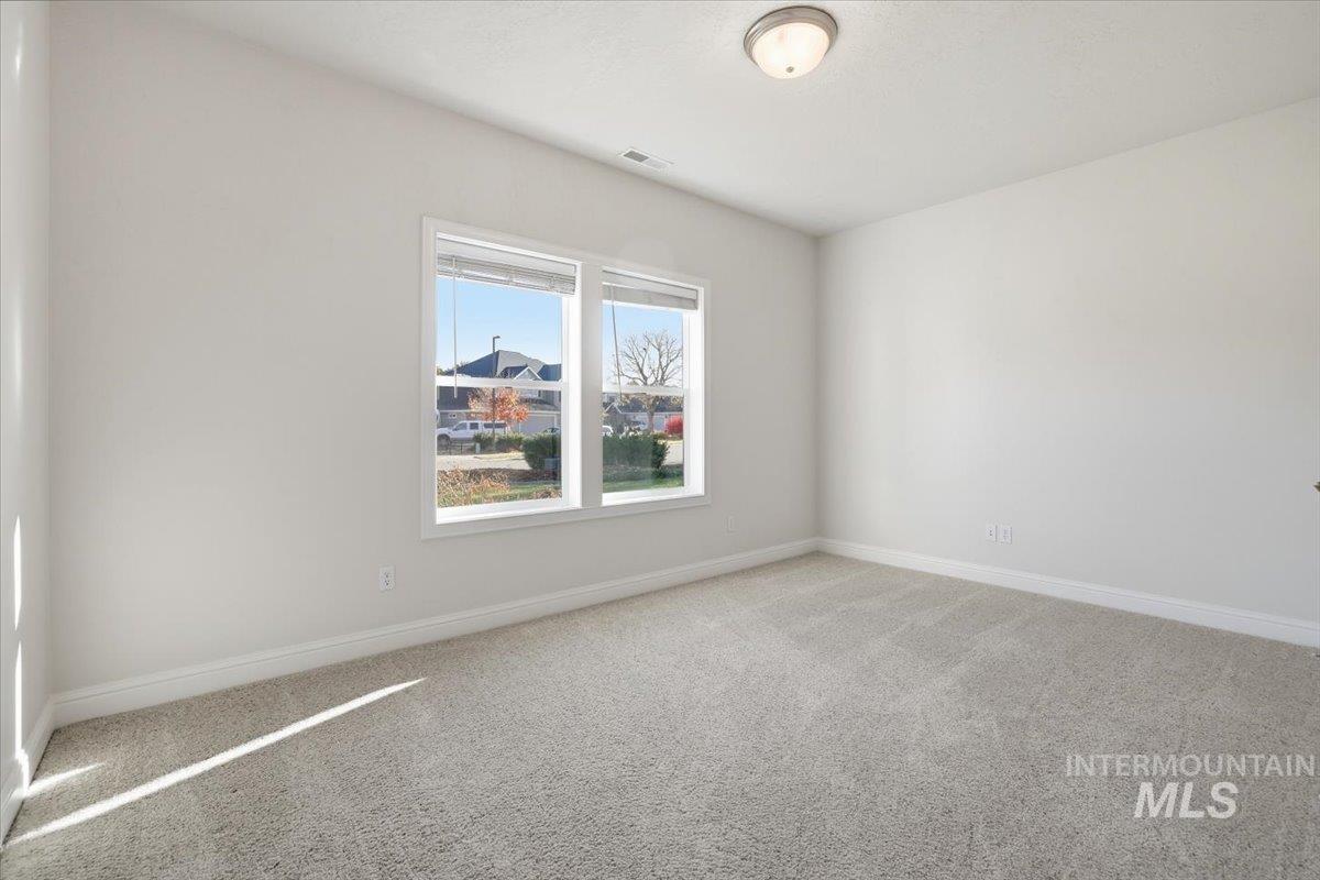 Spare room featuring light carpet and baseboards