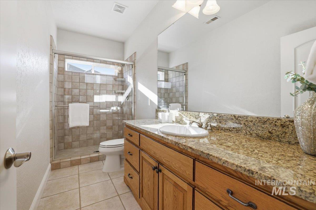 Bathroom with a stall shower, vanity, and light tile patterned flooring