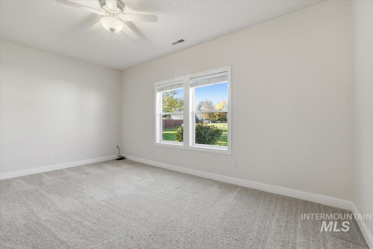 Spare room featuring light carpet and ceiling fan
